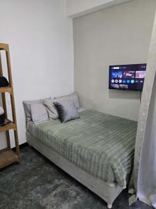 a bedroom with a bed with a tv on the wall at Alquiler de habitaciones en CARACAS in Caracas