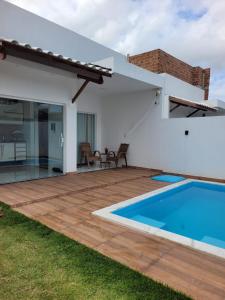 een achtertuin met een zwembad en een huis bij Casa Brisa do Mar in Camaçari
