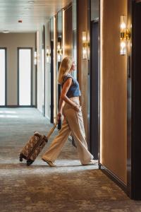 a woman walking down a hallway with a suitcase at Shayna Beach Club in Kérynia