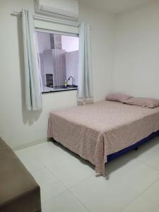 een witte slaapkamer met een bed en een raam bij Casa Brisa do Mar in Camaçari +13 foto's