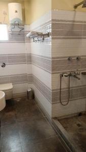 a bathroom with a shower and a toilet at HOTEL SAPTARSHI in Bānkura