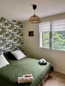 a bedroom with a green bed with a large window at l’Anita in Théoule-sur-Mer