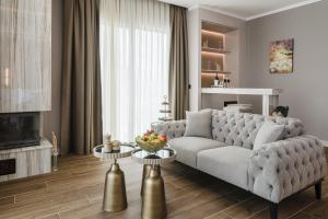 a living room with a couch and two tables at Shayna Beach Club in Kérynia