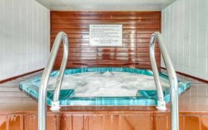 a hot tub in a room with a sign at Village Green 10C in Stowe