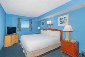 a blue bedroom with a bed and a television at Spacious 1 BR Condo-Breathtaking Oceanfront Views! Bay Watch 706 in Myrtle Beach +36 photos
