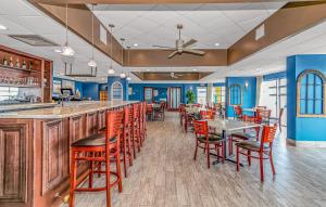 a bar with red chairs and tables in a restaurant at Spacious 1 BR Condo-Breathtaking Oceanfront Views! Bay Watch 706 in Myrtle Beach