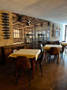 a dining room with tables and chairs and wine racks at Hotel Genevris Cinq in Sauze d'Oulx