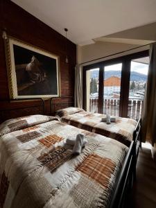 a bedroom with two beds and a large window at Hotel Genevris Cinq in Sauze d'Oulx