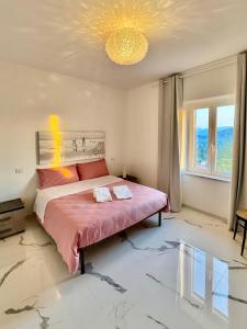 a bedroom with a large bed with a pink comforter at Villa Pina in Arce