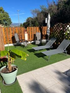a backyard with two lawn chairs and an umbrella at l’Anita in Théoule-sur-Mer