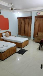 a room with two beds and a couch and a chair at HOTEL SAPTARSHI in Bānkura
