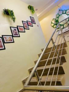 een trap in een huis met foto's aan de muur bij The Majj Hotel Sapele in Sapele +1 foto