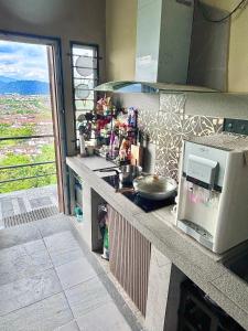 eine Küche mit einer Arbeitsplatte mit Mikrowelle in der Unterkunft KL Ampang Flora Eco Luxury Hilltop Villa in Ampang