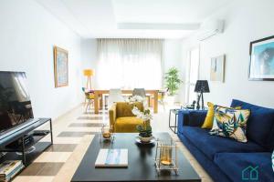 a living room with a blue couch and a table at Le Premium Central luxueux et très confortable in Dār Şāliḩ Bey
