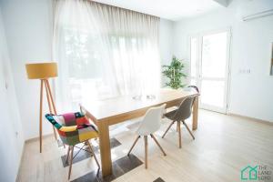a dining room with a wooden table and chairs at Le Premium Central luxueux et très confortable in Dār Şāliḩ Bey