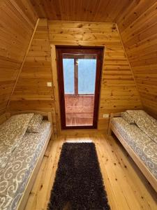 duas camas em um quarto de madeira com janela em ZlatniBor House em Vodice