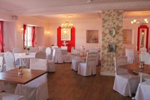 Un comedor con mesas blancas y sillas blancas. en Gasthaus Schiff, en Freiburg im Breisgau