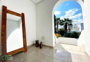 a hallway with a mirror and a view of the ocean at Le Safran renovated and central in La Marsa in Dar el Ouzir