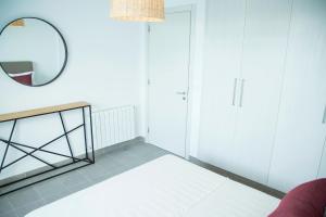 a room with a mirror and a red couch at Modern with garden 5mn from Carthage and Lac in Sidi Daoud +3 photos