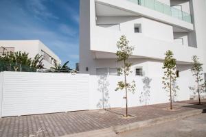 a white building with trees in front of it at Modern with garden 5mn from Carthage and Lac in Sidi Daoud