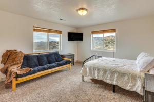 a bedroom with a bed and a couch and windows at Near Dinosaur Natl Monument! High Desert Hideaway in Naples