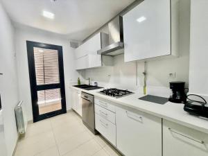 a kitchen with white cabinets and a stove top oven at NEW bright and luxurious 2 bedrooms in Rd Malaga in Sidi Daoud +5 photos