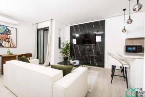 uma sala de estar com um sofá branco e uma cozinha em E24 Grand Luxe tout équipé et central em Dar el Haj Ahmed Souid