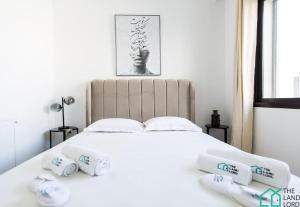 uma cama branca com quatro rolos de toalhas sobre ela em E24 Grand Luxe tout équipé et central em Dar el Haj Ahmed Souid