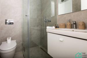 um banheiro com chuveiro, vaso sanitário e pia em E24 Grand Luxe tout équipé et central em Dar el Haj Ahmed Souid