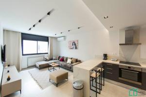 a kitchen and a living room with a couch at Sunset 204 Luxury 2 bedrooms with Gym in Carthage