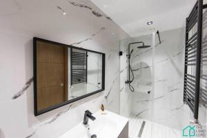 a bathroom with a sink and a shower and a mirror at Sunset 204 Luxury 2 bedrooms with Gym in Carthage +27 photos