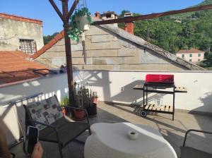 a balcony with a table and a grill on a cart at La casa di Jeannette in Vado Ligure