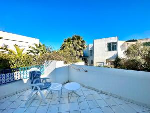 two chairs and a table on a balcony at Safran II Appartement très central avec Terrasse à la Marsa in Dar el Ouzir