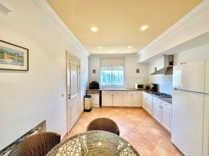 a kitchen with a table and a white refrigerator at Safran II Appartement très central avec Terrasse à la Marsa in Dar el Ouzir