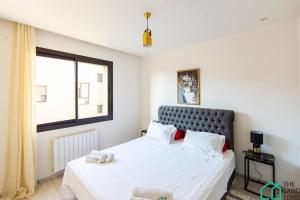 a bedroom with a bed with white sheets and a window at B13 New cosy 1 bedroom in La Marsa in Sidi Daoud