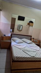 a bedroom with a bed and a mirror on the wall at Hotel Puma Chalé in Sao Paulo