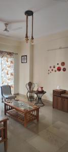 诺伊达An Artist's Paradise的客厅里有一张咖啡桌和几把椅子。