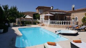 une piscine devant une maison dans l'établissement VILLA ROMA, à Gignac-la-Nerthe