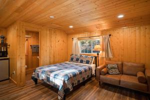 a bedroom with a bed and a chair and a window at Harmels on the Taylor in Almont