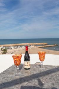 a bottle of wine sitting on a table with two wine glasses at Seaview Apartment N12 in El Perelló
