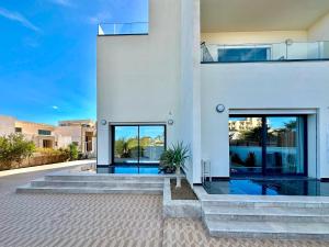 a white house with a swimming pool at Gammarth Touristique piscine commune bord de mer in Chotrana