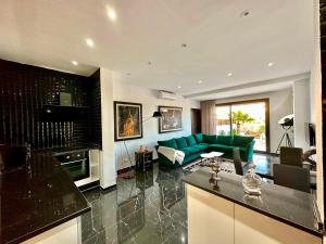 a living room with a green couch and a kitchen at Gammarth Touristique piscine commune bord de mer in Chotrana