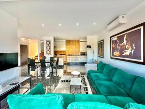 a living room with a green couch and a dining room at Gammarth Touristique piscine commune bord de mer in Chotrana