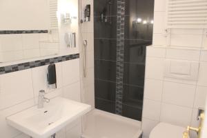 Un baño blanco con lavabo y ducha. en Gasthaus Schiff, en Freiburg im Breisgau 37 fotos más