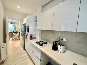 a kitchen with white cabinets and a stove top oven at Villa Jade appartement neuf avec jardin in Dar el Haj Ahmed Souid