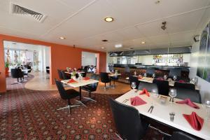 a restaurant with tables and chairs and a bar at Bundaberg International Motor Inn in Bundaberg