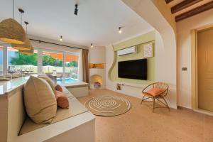 een woonkamer met een bank en een televisie bij Mediterranean Villa with Private Pool in Fethiye