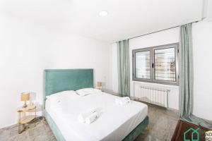 a bedroom with a large white bed and a window at New 1 bedroom with swimming pool next to Lac 2 in El Aouina Station