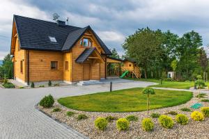 a wooden house with a circular driveway at Gruszowa Villa in Kalwaria Pacławska
