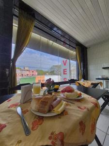 a table with plates of food on a table with a window at Yves Hotel in Porto Velho